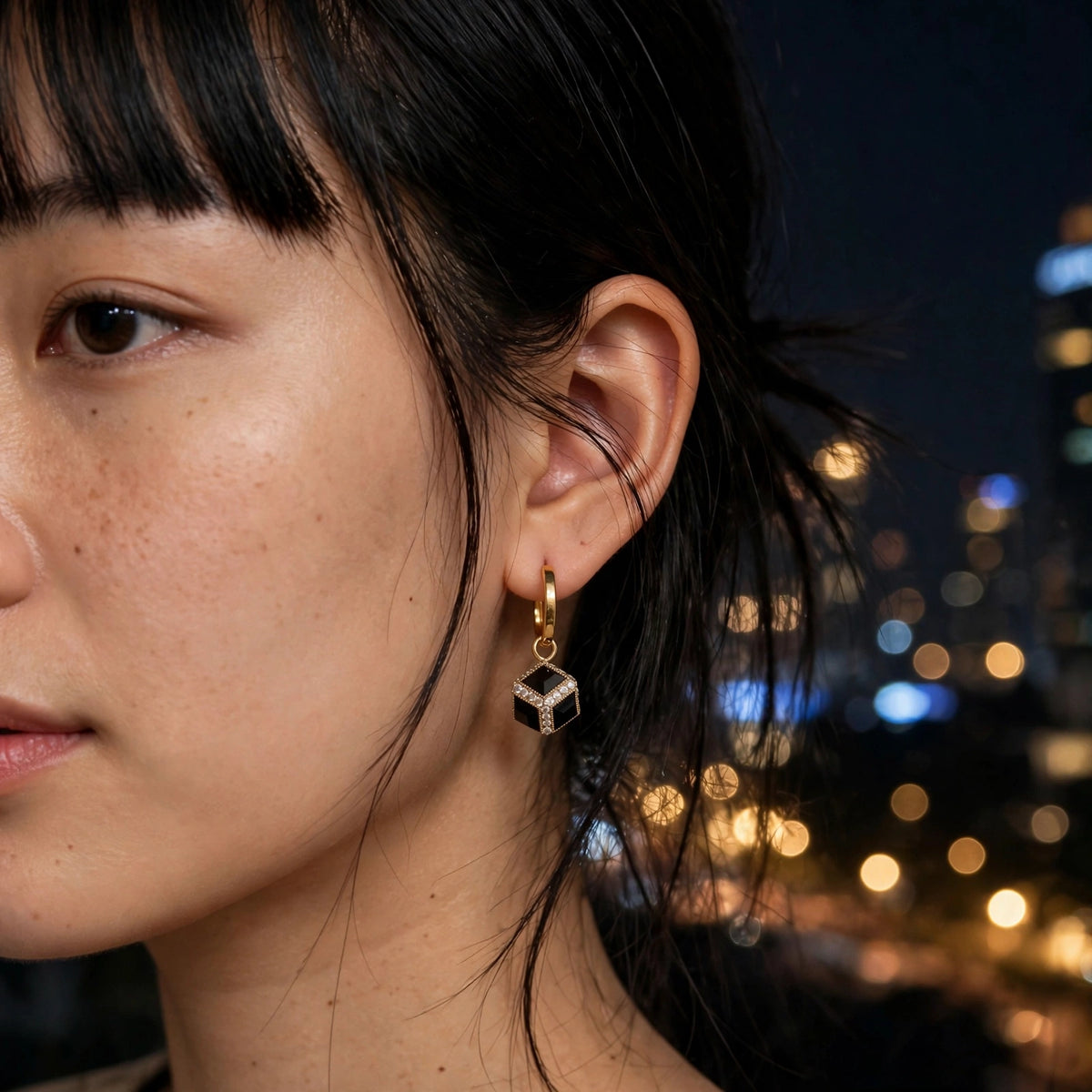 Model wearing the Black Cube Huggie Hoop Earrings