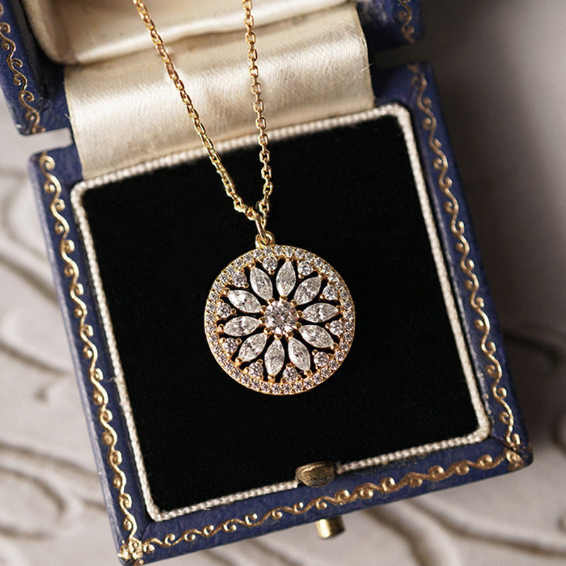 Gold sunburst medallion necklace in a box