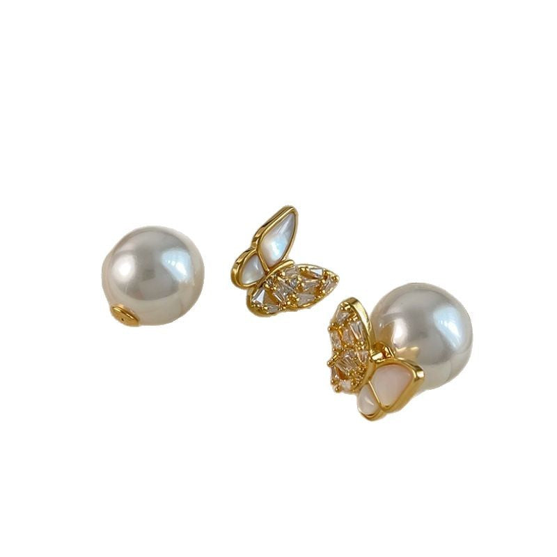 Butterfly and pearl stud earrings on white