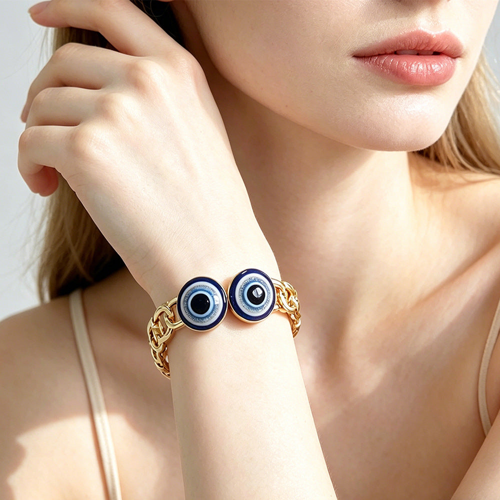 Gold evil eye openwork link bangle worn on the wrist