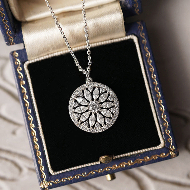 Silver sunburst medallion necklace in a box